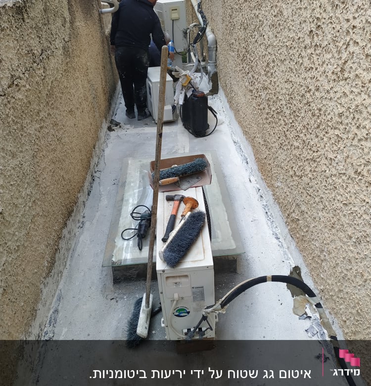 אדם עובד על איטום גג עם כלים וחומרי איטום